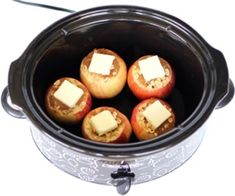 four baked apples with butter and parmesan cheese in an electric crockpot