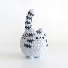 a crocheted cat with black and white stripes