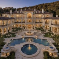 an aerial view of a mansion with a pool in the foreground and trees on the other side