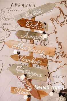 several wooden signs are hanging on a map with words written in different languages that spell out the names