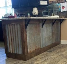 a kitchen island made out of an old metal container and some wood planks on the floor