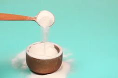 a wooden spoon pouring sugar into a bowl