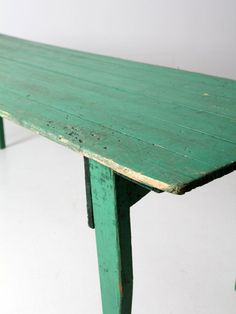 an old green wooden table on a white floor