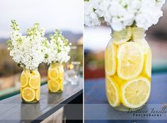 two vases filled with lemon slices and white flowers