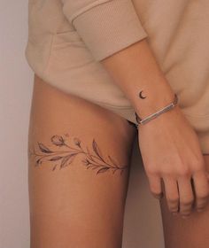 a woman with a tattoo on her thigh and the lower half of her leg is shown