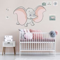 a baby's room with an elephant decal on the wall and a white crib