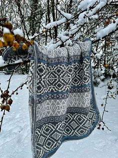 a blanket hanging from a tree in the snow