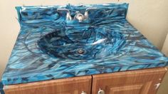 a bathroom sink that is made out of blue marble and has two drawers underneath it