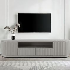 a flat screen tv sitting on top of a white entertainment center