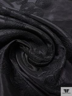 black silk fabric with an intricate design on the bottom and side, as well as a dark background