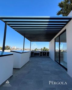 an outdoor covered patio area with white walls and black metal awnings on the roof