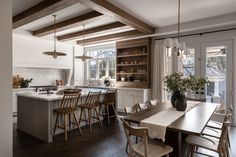 a kitchen with an island, table and chairs next to the stove in the room