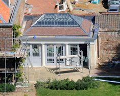 an aerial view of a house being built in the middle of some brick and stone buildings