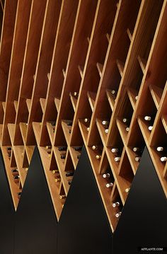 the wine rack is made out of wood and has several bottles on it, all lined up in rows