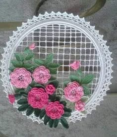 crocheted doily with pink flowers and green leaves