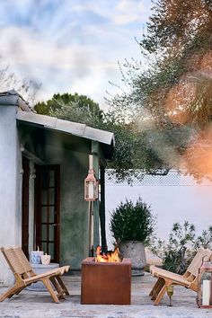 an outdoor fire pit with chairs around it