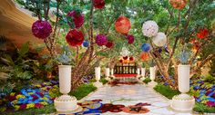 an outdoor walkway decorated with paper flowers and greenery