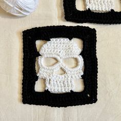 two crocheted skull coasters sitting on top of a table