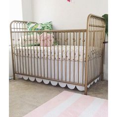 a baby crib in a room with pink and white rugs