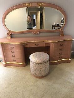 an antique vanity with mirror and stool