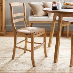 a wooden table with two chairs next to it and a white couch in the background