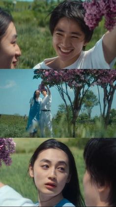 two people standing next to each other with flowers in their hair and one person holding a flower