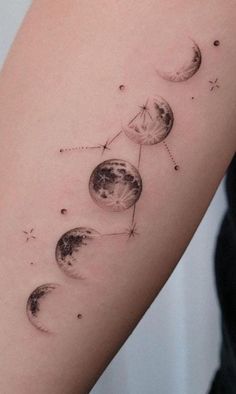 a woman's arm with three phases of the moon and stars on each side