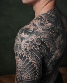 a man with tattoos on his chest and shoulder