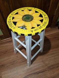 a painted stool with a sunflower on the top and words written in cursive writing