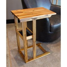 a wooden table with a remote control on it next to a chair and leather couch