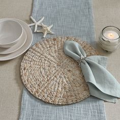 a place setting with plates, napkins and candles