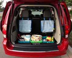 the back end of a red car with its trunk open and several items in it