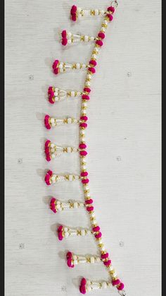 the beaded necklace is adorned with pink and white beads