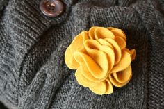 a gray sweater with a yellow flower on it