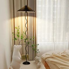 a white bear statue sitting on top of a table next to a lamp and bed