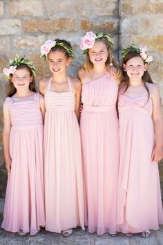 three girls in pink dresses standing next to each other with flower crowns on their heads