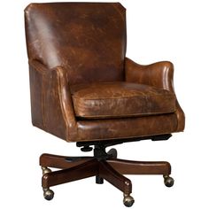 a brown leather office chair sitting on top of a wooden desk