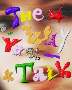 the word talk spelled out in colorful plastic letters on a brown surface with stars and shapes