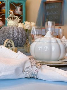 the table is set with white dishes, silverware and napkins for guests to eat