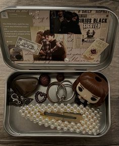 an open tin box with keychains and other items in it