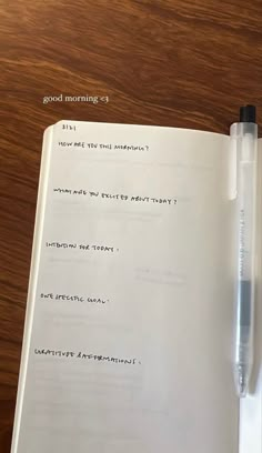 an open notebook with writing on it and a pen resting on top of the book