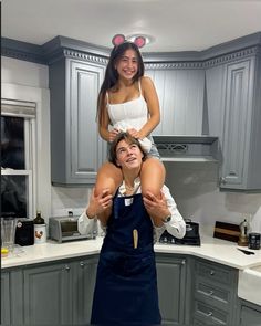 a woman is lifting another woman in the air while standing on top of her head