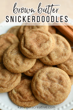 brown butter snickkerdoodles on a white plate with cinnamon sticks in the background