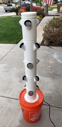 a red and white bucket sitting on top of a sidewalk