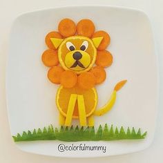 a paper plate with an orange cut out of a lion on it's face