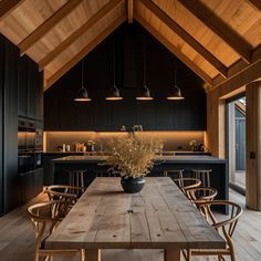 a large wooden table with chairs around it in the middle of an open floor plan