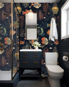 a bathroom with a toilet, sink and wallpaper in it's design style