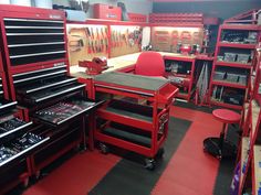 a room filled with lots of red workbenches