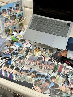 an open laptop computer sitting on top of a desk covered in pictures and magnets