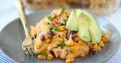 a close up of a plate of food with an avocado on the side